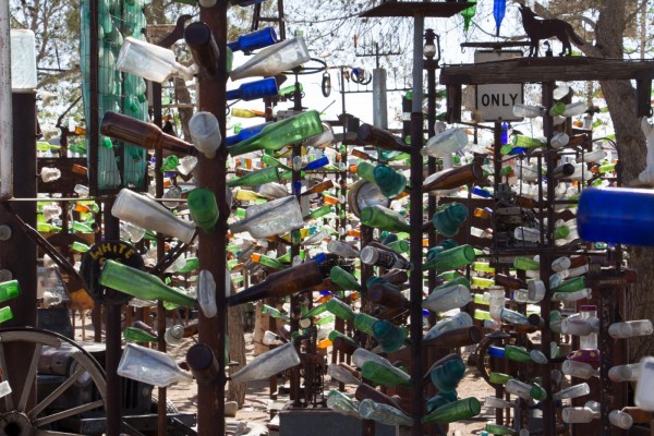 Hundreds of colored bottles on bottle trees